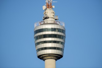 Architektonischer Fernsehturm mit Glas- und Metallelementen gegen blauen Himmel,