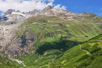 View of Furka pass road Alpine pass with tight bends hairpin bends on steep mountain slope above