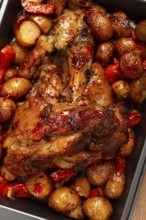 Pork knuckle, baked with vegetables, new potatoes, on a baking sheet, homemade, no people