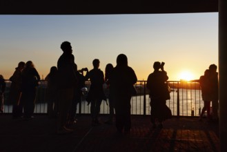 Crowd enjoying the view from the Elbphilharmonie over the Elbe at sunset, silhouettes, Plaza