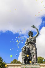 Colourful balloons rise high above the statue of Bavaria into the white-blue sky, grand finale of
