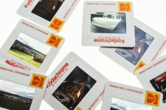 Many framed Kodachrome slides on a light table with magnifying glass, top shot