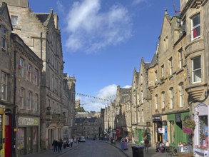 Historic street lined with old buildings under a clear sky, Old Town, Edinburgh, Scotland, United