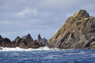 Rock formations by the sea with undulating water and cloudy sky, Isles of Scilly, Cornwall, Great