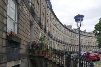 Historic street scene with buildings in a semicircle, flowers and a car, New Town, Edinburgh,