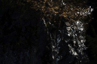 Water of a stream flowing over rocks, light reflections, Otroya or Otrøya island, Møre og Romsdal,