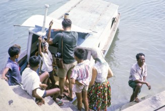Picnic party embarking on boat for the islands, East coast, Mersing, Johor, Malaya, Malaysia, south