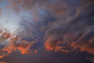 Clouds illuminated by the sun in the evening sky, Bavaria, Germany