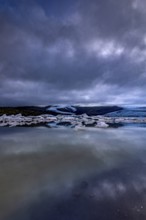 Ice floes, lake, shore, stones, glacier tongue behind, glacier, glacier lagoon, cloudy, summer,