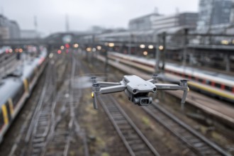 Ein Fernpilot steuert sein Quadrocopter, Drohne illegal über Bahnhofsgelände, Bahngelände,