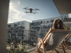 Ein Fernpilot steuert sein Quadrocopter, Drohne in einem dicht besiedeltem Wohngebiet und nähert