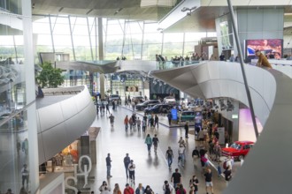 Modern interior with people and exhibited cars in a light-flooded environment, BMW Welt, Munich,