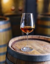 Glass of 10-year-old tawny wine placed on a barrel in a vineyard restaurant, AI generated