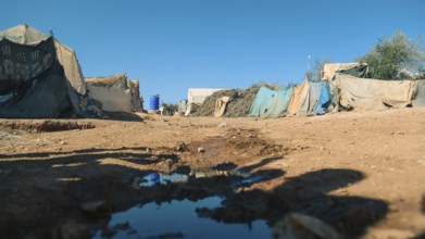 Worn-out tents housing Syrian refugees near the Turkish border, showing the dire humanitarian