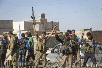 Fighters from the Free Syrian Army celebrate victory after capturing villages that were under the