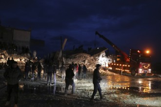 Civil defense teams attempt to rescue civilians trapped under the rubble after a powerful
