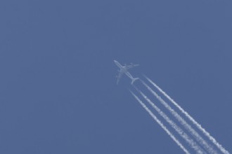 Airbus A340-300 jet aircraft of Lufthansa airlines in flight in a blue sky with vapour trails or