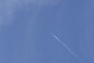 Boeing 737 jet passenger aircraft of Norweign Air with a vapour trial or contrail behind flying in
