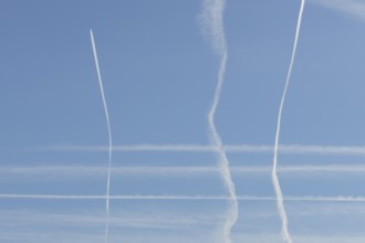 Jet aircraft vapour trails or contrails in a blue sky, England, United Kingdom