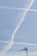 Jet aircraft vapour trails or contrails in a blue sky, England, United Kingdom
