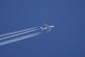 Airbus A380 jet passenger aircraft of Emirates airlines flying with vapour trails or contrails