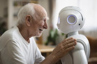 An elderly man in a nursing home smiles and communicates with a humanoid robot, carer robot, symbol