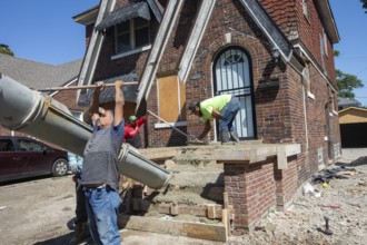 Detroit, Michigan, Workers rebuild front porch of a house they are remodeling in the Morningside