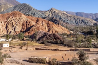 Young people playing football, with coloured hills in the background, erosion, Purmamarca, Jujuy,