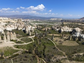 Breathtaking rock formations and valleys in Cappadocia under a blue sky, aerial view, Love Valley,