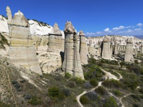 Impressive rock formations under a blue sky in Cappadocia with hiking trails, aerial view, Love