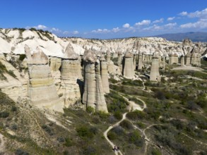 Panorama of imposing rocks and cliffs with a winding path in sunny surroundings, aerial view,