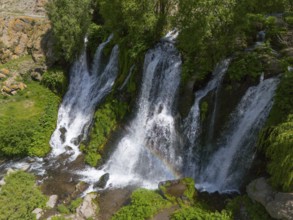 Waterfalls with lush greenery and rainbow in the sunlight, aerial view, Shaki waterfall, Shaki,