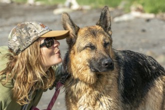 Woman blowing in her German Shepherd's ear, the dog is annoyed, Gaspesie Region, Province of