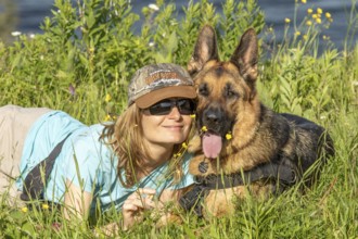 Woman and her German Shepherd lying in the grass, Woman and her German Shepherd lying in the grass,