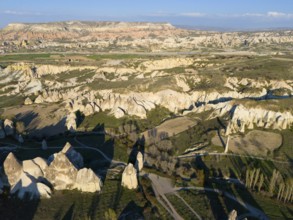 Vast landscape with hills and unique rock formations in the sunlight, aerial view, Göreme National