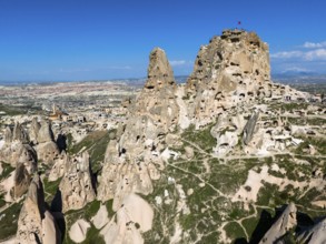 Rocky landscape with ancient rock structures under a clear blue sky in Cappadocia, aerial view,