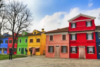 Strollers, typical street scene in winter, colourful facades of fishermen's houses in Burano,