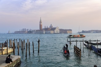 Boat dock at St Mark's Square, San Giorgio Maggiore church in the background, evening sky, Venice,