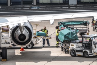 Aircraft being unloaded after landing, luggage being loaded, Düsseldorf International Airport.
