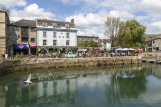People sitting outside The Three Crowns pub quayside harbour, The Barbican, Plymouth, Devon,
