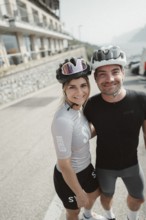 Woman and man riding racing bikes in Italy on Lake Garda
