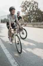 Woman and man riding racing bikes in Italy on Lake Garda