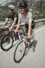 Woman and man cycling on Lake Garda in Italy. Sunny weather and dolce vita