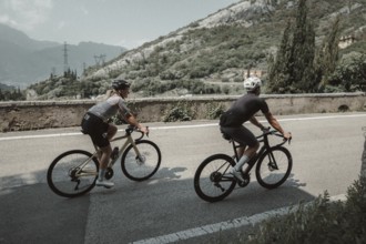 Woman and man cycling on Lake Garda in Italy. Sunny weather and dolce vita