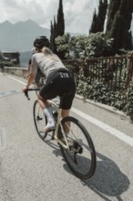 Young woman riding a racing bike on Lake Garda. Sunny weather and dolce vita