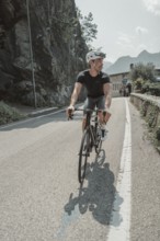 Young man riding a racing bike on Lake Garda. Sunny weather and dolce vita