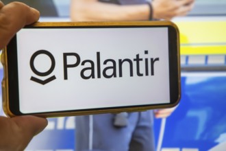 (Photomontage) Palantir symbolic image: PALANTIR logo on a smartphone, a police officer in the