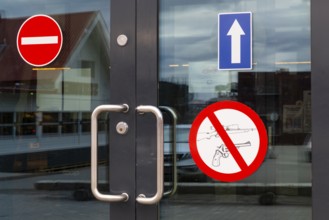 Firearms warning sign, entrance door, retail shop, Longyearbyen, Spitsbergen, Svalbard