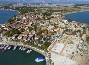 Picturesque view of a coastal town with ancient ruins and red roofs by the sea, aerial view,
