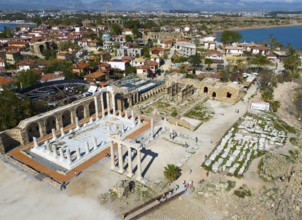 Ancient ruins next to a town overlooking the sea. Historical and scenic scenery, aerial view,